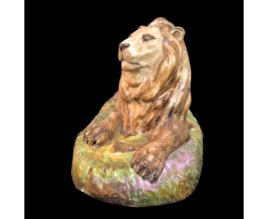 Scultura in porcellana policroma raffigurante leone accovacciato.Manifattura Samson.Francia.
