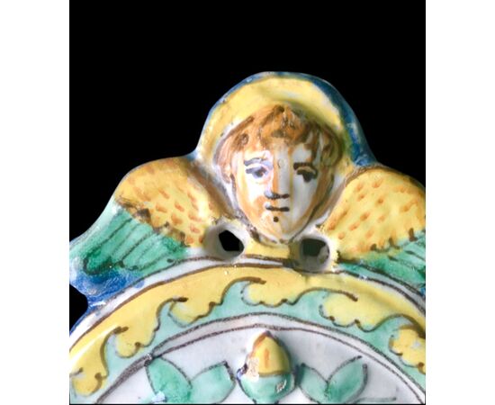 Acquasantiera in maiolica con motivi vegetali e geometrici in rilievo e figura di Madonna con Bambino al centro.Manifattura di Deruta.