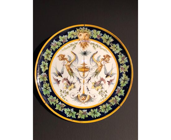 Coppia di piatti in maiolica decorati a raffaellesche nell’umbone e motivi a tralci di vite sulla tesa.Manifattura Ginori.