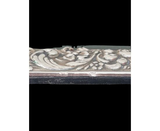 Cornice-specchiera in argento con motivi vegetali e rocaille e scudo superiore.Titolo 925.