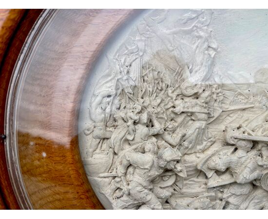 Bassorilievo ovale entro cornice lignea  in schiuma di mare ( magnesite) raffigurante scena di battaglia. Firma: Justin