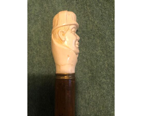 Bastone con pomolo in osso raffigurante figura maschile con cappello e pipa. 