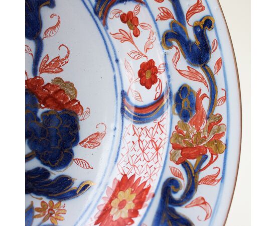 Serie di tre piatti in maiolica decorati a motivi floreali in policromia