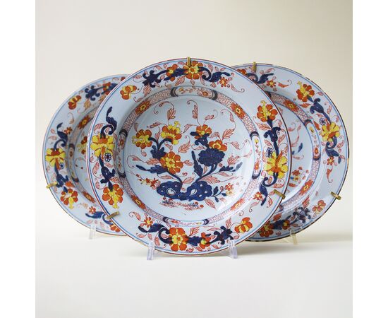 Serie di tre piatti in maiolica decorati a motivi floreali in policromia