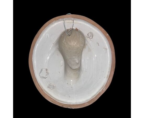 Formella ovale in maiolica con viso di fanciulla in rilievo,copia di un esemplare di Andrea della Robbia.Manifattura Cantagalli,Firenze.