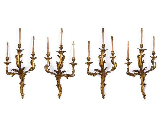 Quattro grandi applique a tre luci in bronzo dorato, fine XIX secolo, Francia, stile Luigi XV 