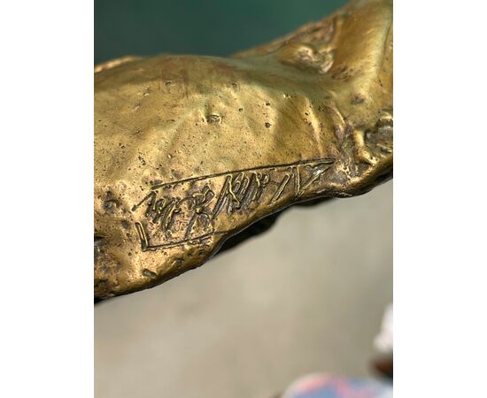 Scultura in bronzo dorato con base lignea.Firmata.