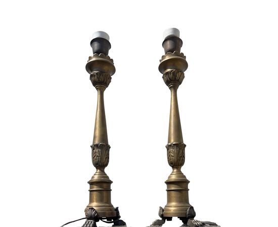 Coppia di candelieri in bronzo trasformati a lampade con tre piedi leonini e fusto con foglie stilizzate.