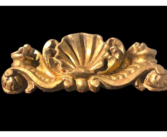 Mensola-applique in legno intagliato e foglia oro con decoro rocaille e conchiglia.