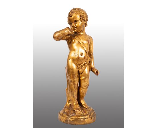 Scultura antica in legno dorato e intagliato raffigurante un putto in atteggiamento gioioso. Firenze XIX secolo.