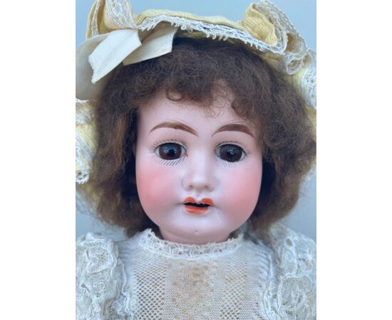 Bambola con testa in bisquit  e corpo in cartapesta.Abiti originali.Firma 1902 e lettera I.