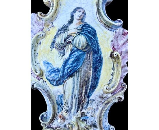 Acquasantiera in maiolica con bordo rocaille e decoro pittorico raffigurante la Madonna con cherubini.Manifattura Minghetti.Bologna.