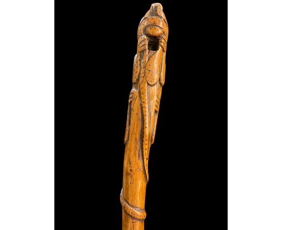 Bastone popolare in pezzo unico di legno inciso con figura di giaguaro che attacca un serpente.