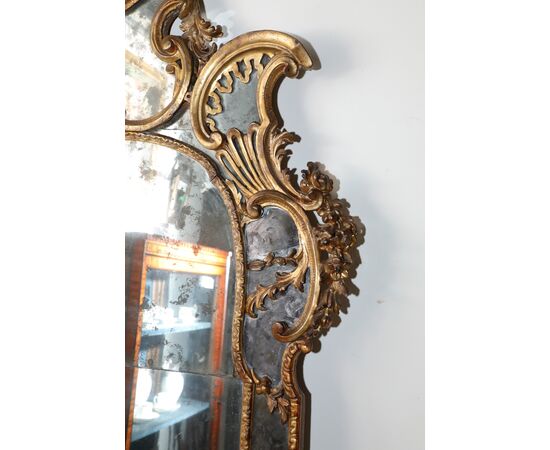 Grande specchiera in legno dorato con doppi specchi e cimasa con ventaglio