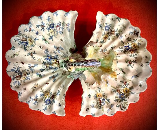 Centrotavola in maiolica a forma di conchiglia bivalve con presa a drago e decoro a fiori e insetti.Angelo Minghetti,Bologna.