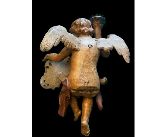 Scultura in legno policromo raffigurante un angelo con cornucopia e scudo rocaille con iscrizione.Paesi Bassi.