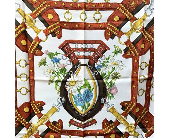 HERMES Foulard Vintage in Seta Col. Marrone <p style="text-align:left;">HERMES Silk scarf named 'Aux Champs', created by artist Cathy Latham, and first issued in 1970. 100% Silk. Hand rolled edges. Brown colorway. 'HERMES Paris' signature with copyright s