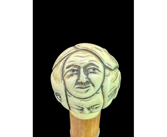 Bastone con pomolo tondo in avorio scolpito con maschere della commedia dell’arte.Giappone.