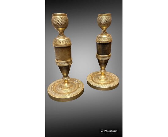 Coppia di candelieri Impero in bronzo dorato e patinato scuro.