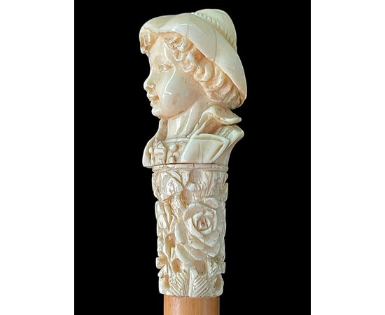 Bastone con pomolo in avorio raffigurante un busto di giovane con cappello.