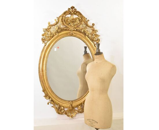 SPECCHIO ANTICO OVALE CON CIMASA, FIORI E VOLUTE, SPECCHIERA  ANTICA, CORNICE DORATA, DEL XIX SECOLO. (SPO171)