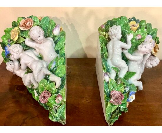 coppia di vasi applique angolari decorati con putti e fiori in rilievo. manifattura Minghetti di Bologna.