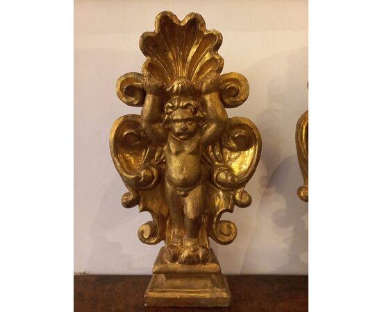 Coppia di putti stanti in una palma