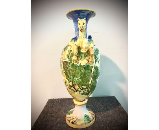 Majolica vase with lateral dragons grips and decorated with a bacchanal scene.Manifattura Minghetti.Bologna.     