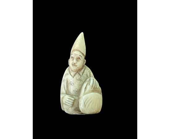 Netsuke in avorio raffigurante personaggio maschile.Giappone.