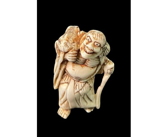 Netsuke in avorio raffigurante personaggio maschile.Giappone.