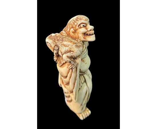 Netsuke in avorio raffigurante personaggio maschile.Giappone.