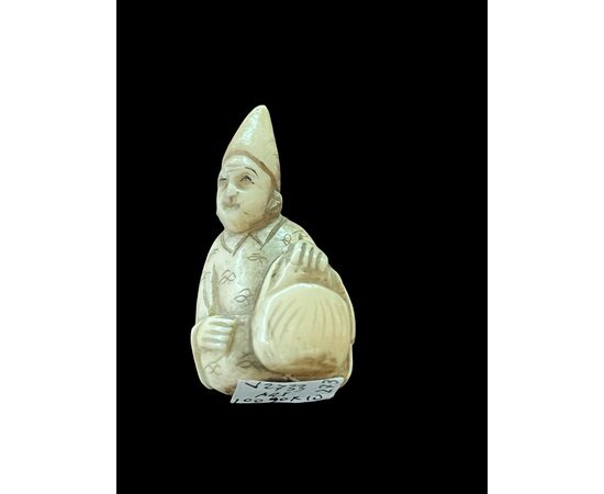 Netsuke in avorio raffigurante personaggio maschile.Giappone.