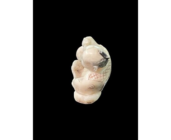 Netsuke in avorio raffigurante personaggio maschile.Giappone.