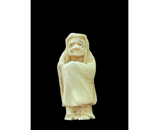 Netsuke in avorio raffigurante personaggio maschile.Giappone.