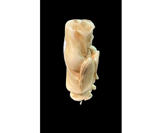 Netsuke in avorio raffigurante personaggio maschile.Giappone.