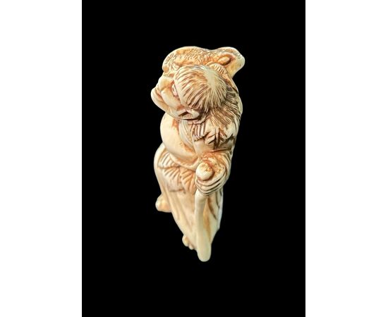 Netsuke in avorio raffigurante personaggio maschile.Giappone.