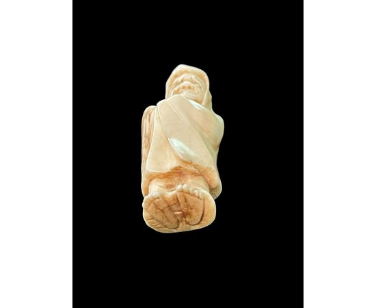 Netsuke in avorio raffigurante personaggio maschile.Giappone.