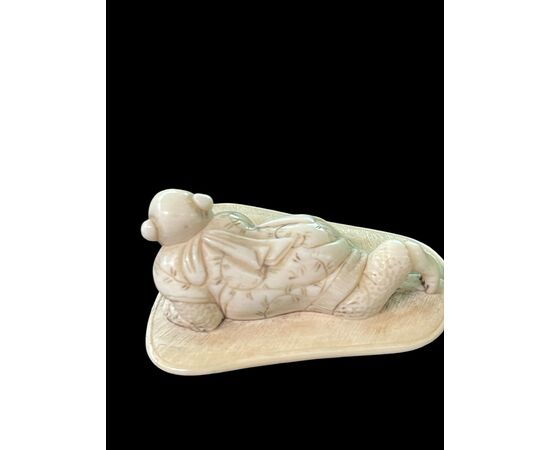 Netsuke in avorio raffigurante personaggio maschile.Giappone.