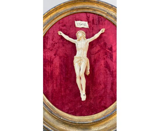 Cristo in avorio su cornice ovale in legno e foglia oro.