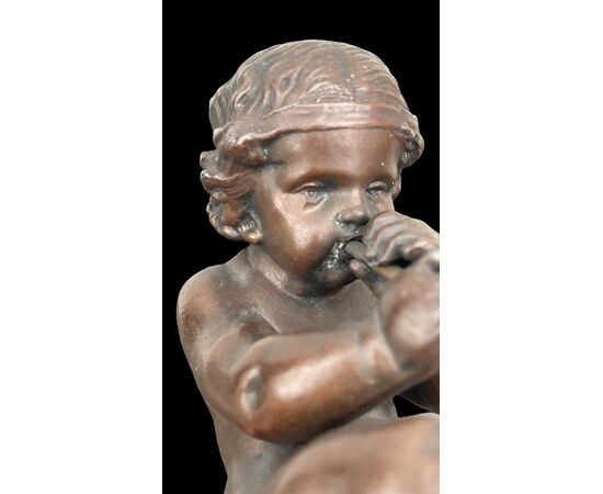 Piccola scultura in bronzo raffigurante un putto che suona il flauto.