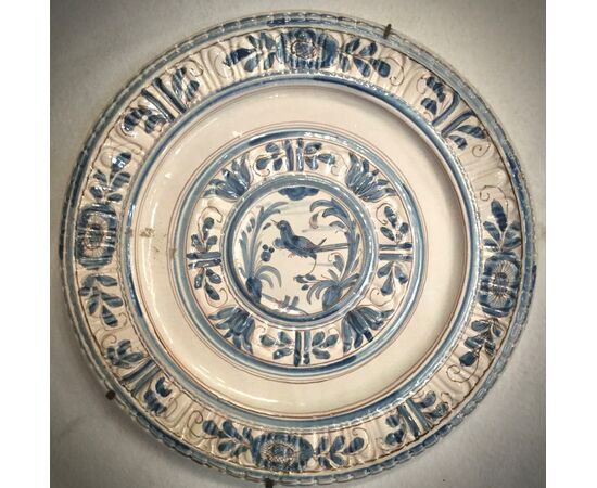 Large blue monochromatic pod plate with stylized floral decorations and bird figure in the umbo.Manufactured in Pavia.     