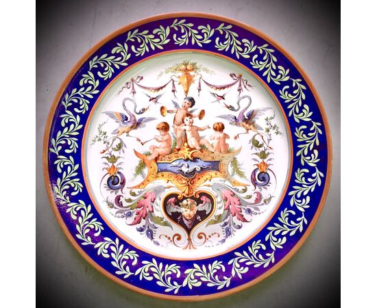 Large majolica plate decorated with cherubs, grotesques and plant motifs.Ginori manufacture.     