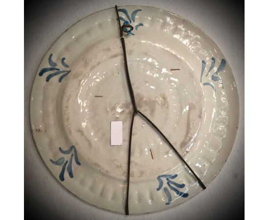 Large blue monochromatic pod plate with stylized floral decorations and bird figure in the umbo.Manufactured in Pavia.     