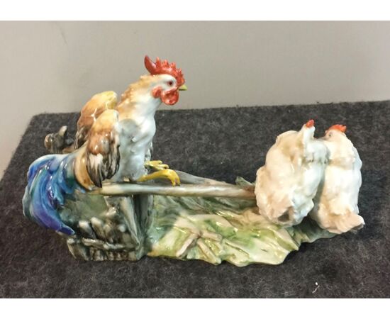 Gruppo in ceramica policroma raffigurante Gallo e due galline nel pollaio.Manifattura di Guido Cacciapuoti.Milano
