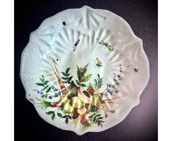 Serie di quattro piatti crespine in maiolica baccellata decorati con frutta e insetti,vendibili singolarmente.Mamifattura di Angelo Minghetti.Bologna.