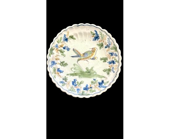 Piatto in maiolica decorato  con uccellino e motivi vegetali.Manifattura Coppellotti.Lodi.