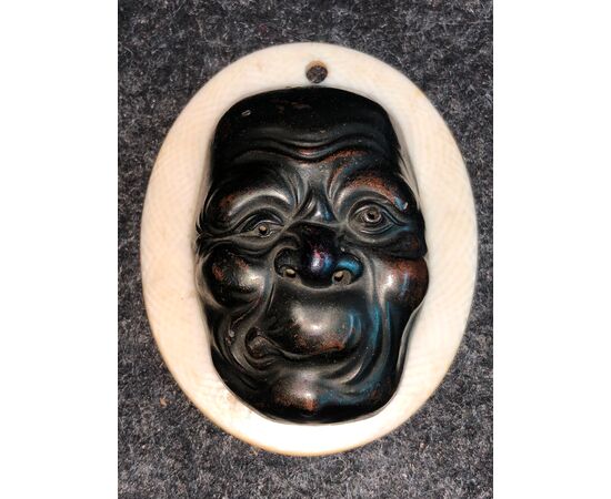 Piccola maschera con figura maschile grottesca in bronzo.Giappone