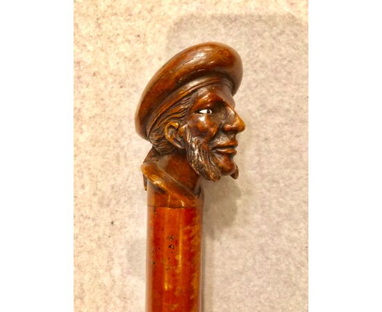 Bastone con pomolo in legno raffigurante figura maschile con basette e cappello.