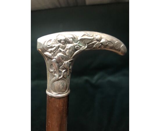 Silver stick with floral decoration and angels.     