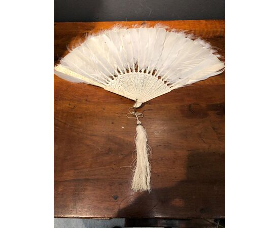 Ivory fan engraved with popular scenes and bird feathers. China.     